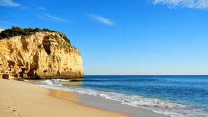 A beach with a sandy shore, a cliff, and the ocean. - Algar Seco Parque (Lagoa)