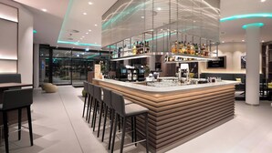 A modern bar area with a curved counter, bar stools, and a glass enclosure for the bar. - Courtyard by Marriott Wolfsburg (Wolfsburg)
