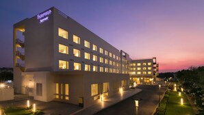 Un hotel Fairfield Marriott de varios pisos, con ventanas iluminadas y una entrada bien iluminada.