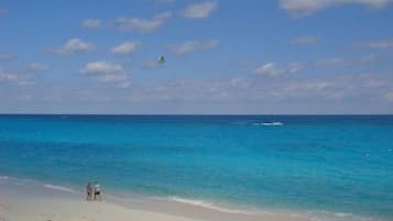 On the beach, white sand, sun-loungers, beach towels