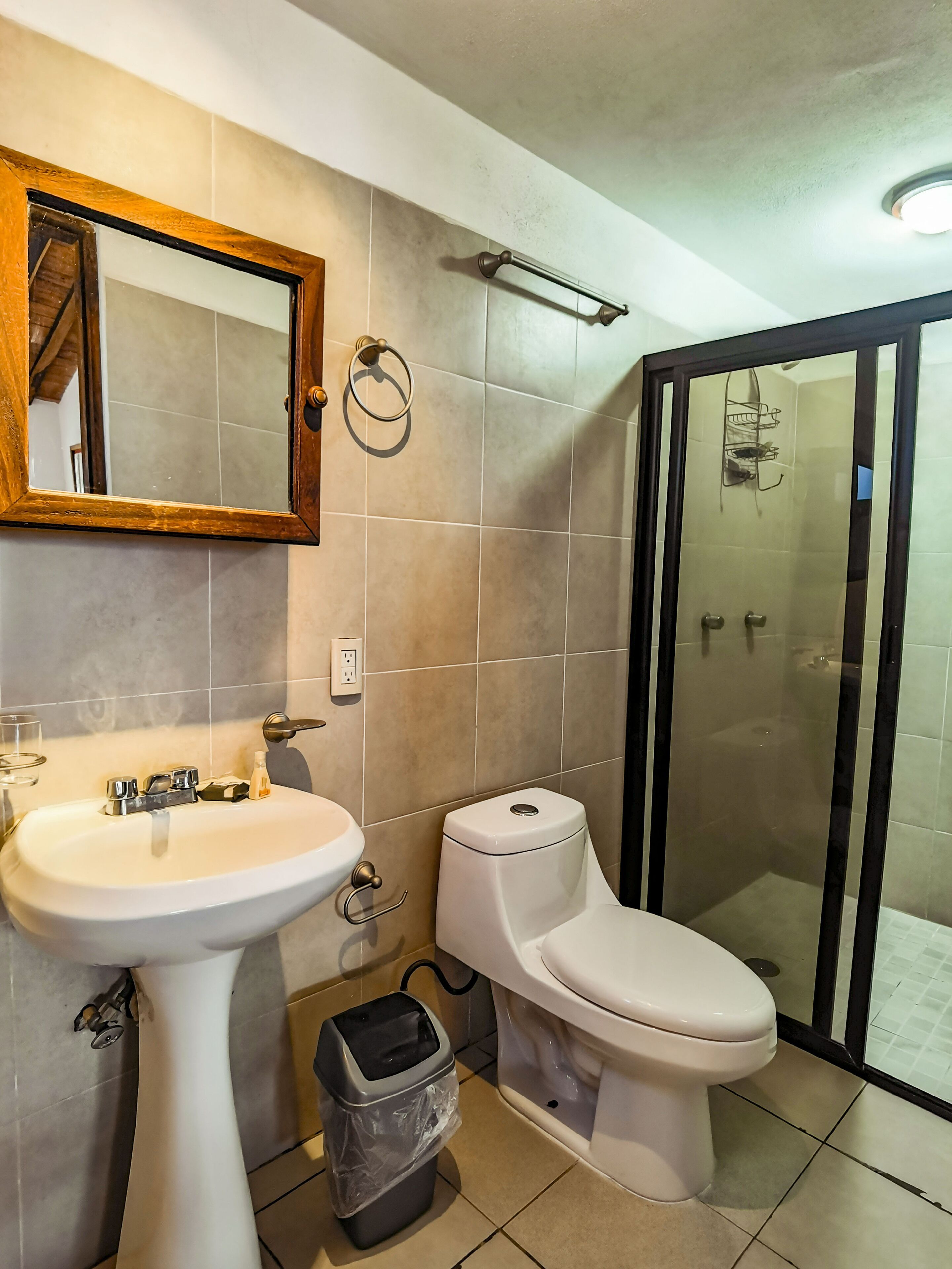 A bathroom with a sink, toilet, and a glass-enclosed shower.