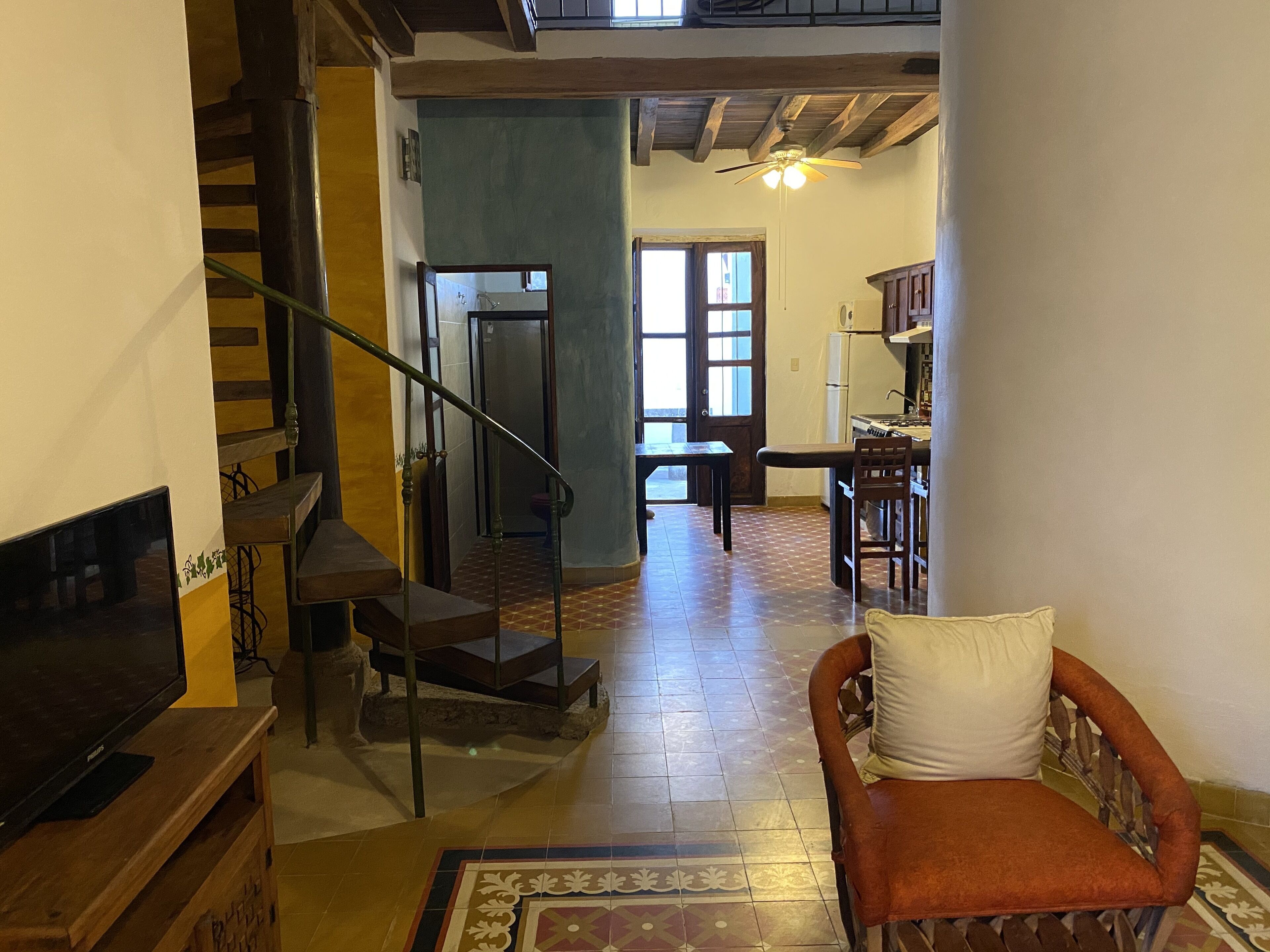 Un amplio salón con una escalera, un comedor y una cocina.