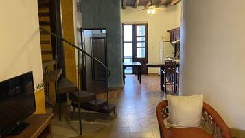 Un amplio salón con una escalera, un comedor y una cocina.