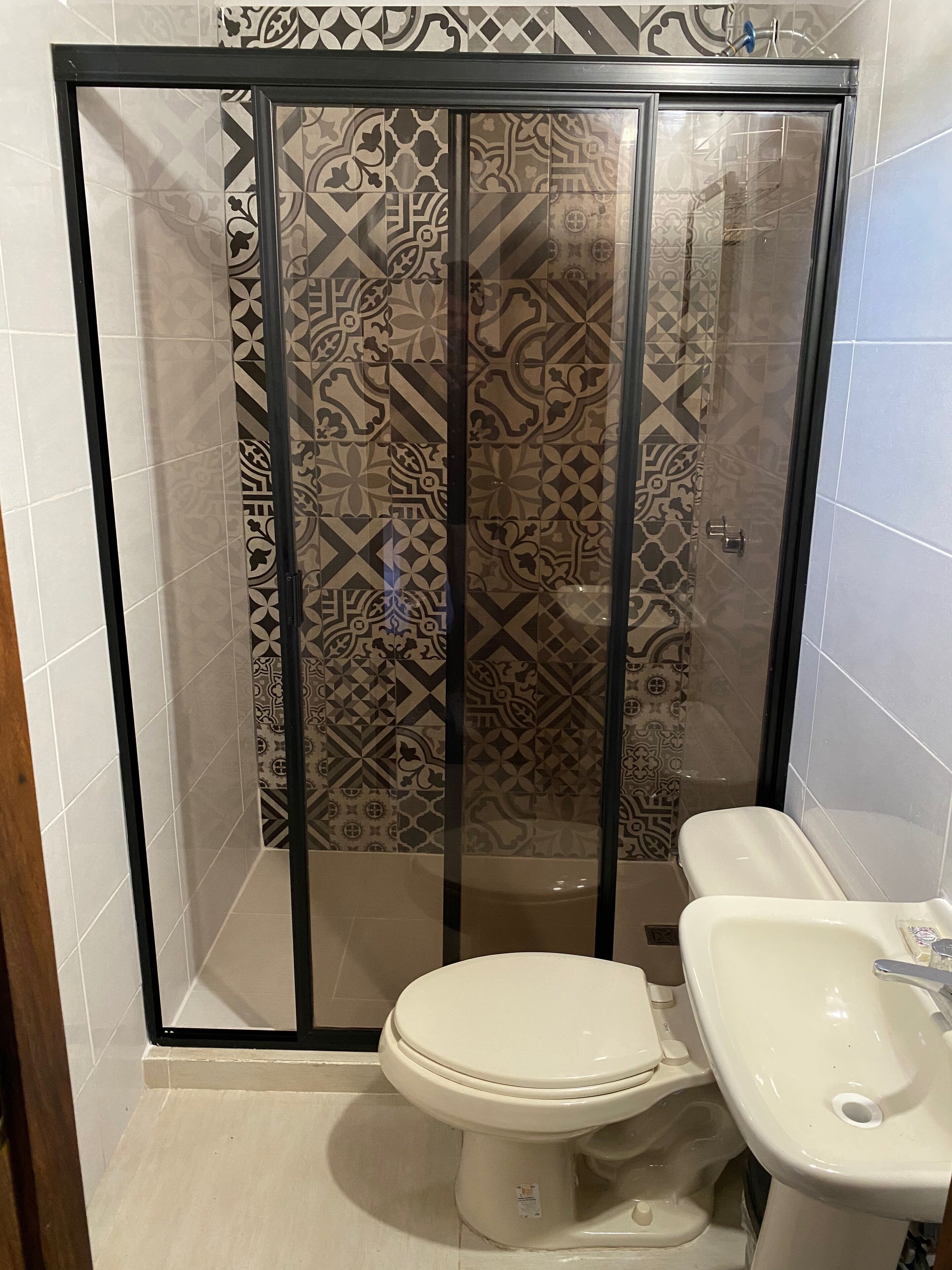 Ein Badezimmer mit Duschkabine, Toilette und Waschbecken.