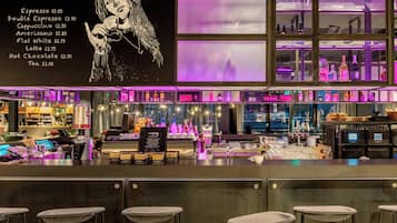 Una zona de bar con una pizarra de menú, taburetes y estantes llenos de botellas.
