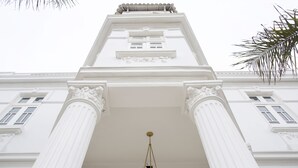 Um edifício com colunas brancas e um lustre central.