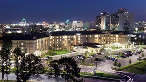 Un hôtel à étages, doté d’un parking et offrant une vue sur les lumières de la ville la nuit.