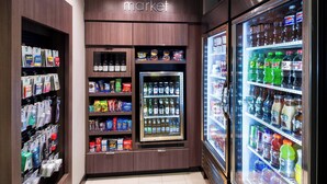 Un présentoir réfrigéré pour boissons dans un magasin, où sont exposées diverses boissons et collations.