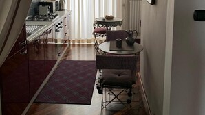 A modern kitchen with a dining area, including a table with chairs and a rug.