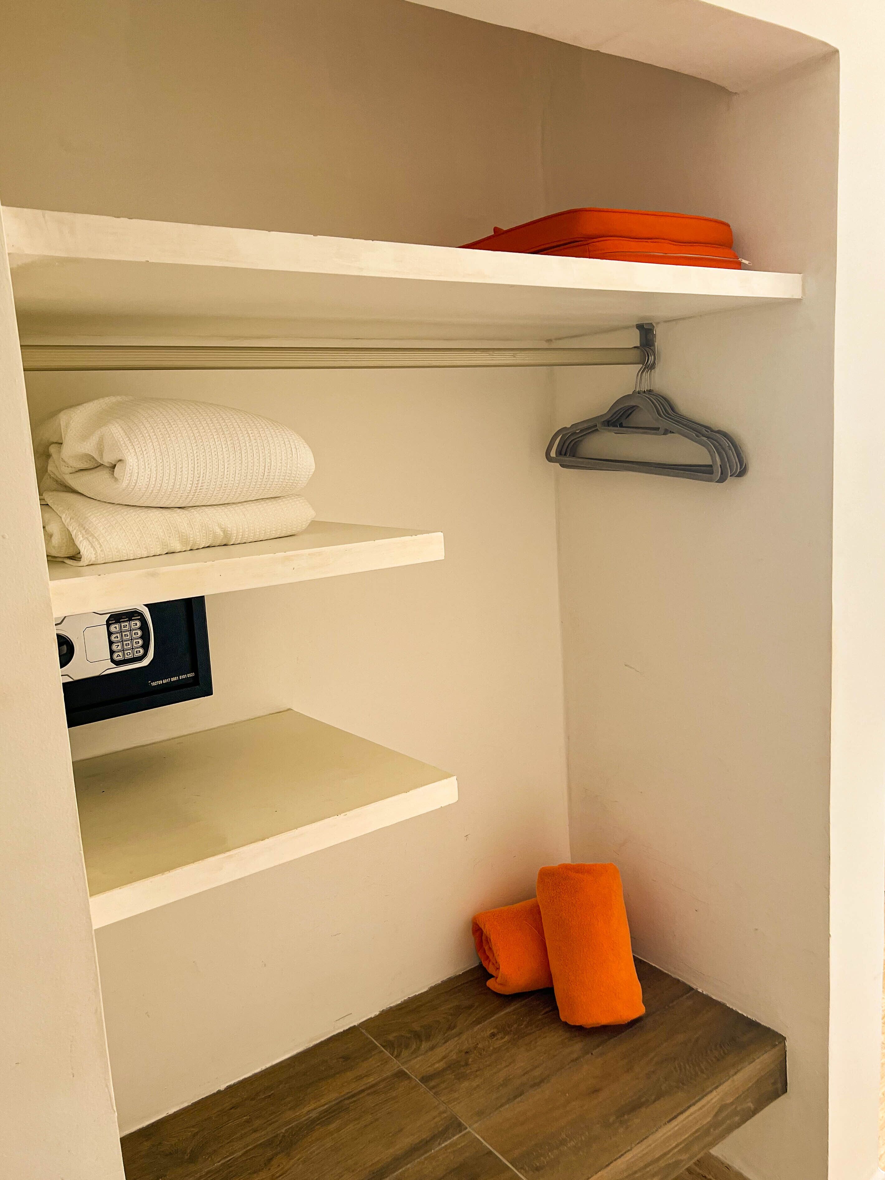 A storage area with shelves, a hanging rack, and a wooden bench.
