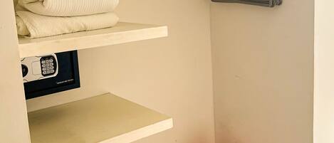 A storage area with shelves, a hanging rack, and a wooden bench.