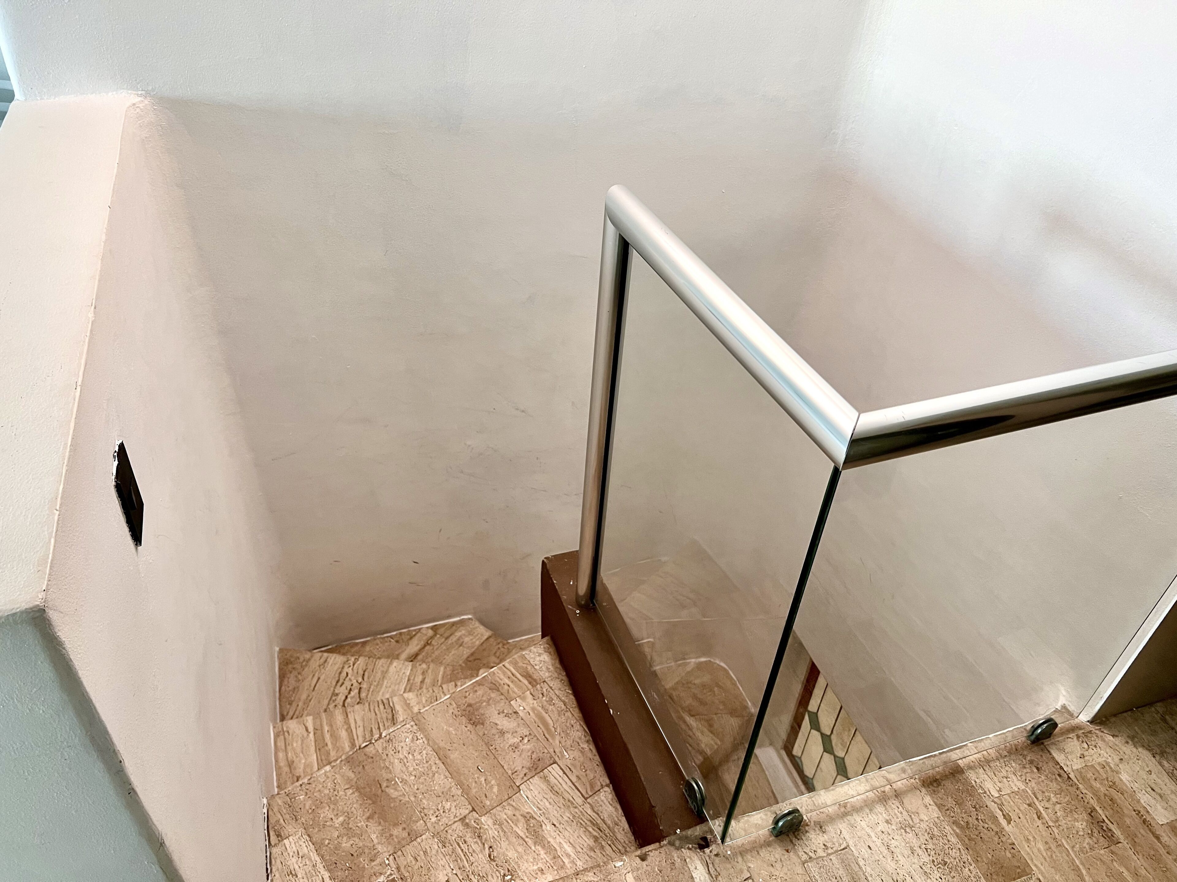 A staircase with a glass railing and a wooden floor.