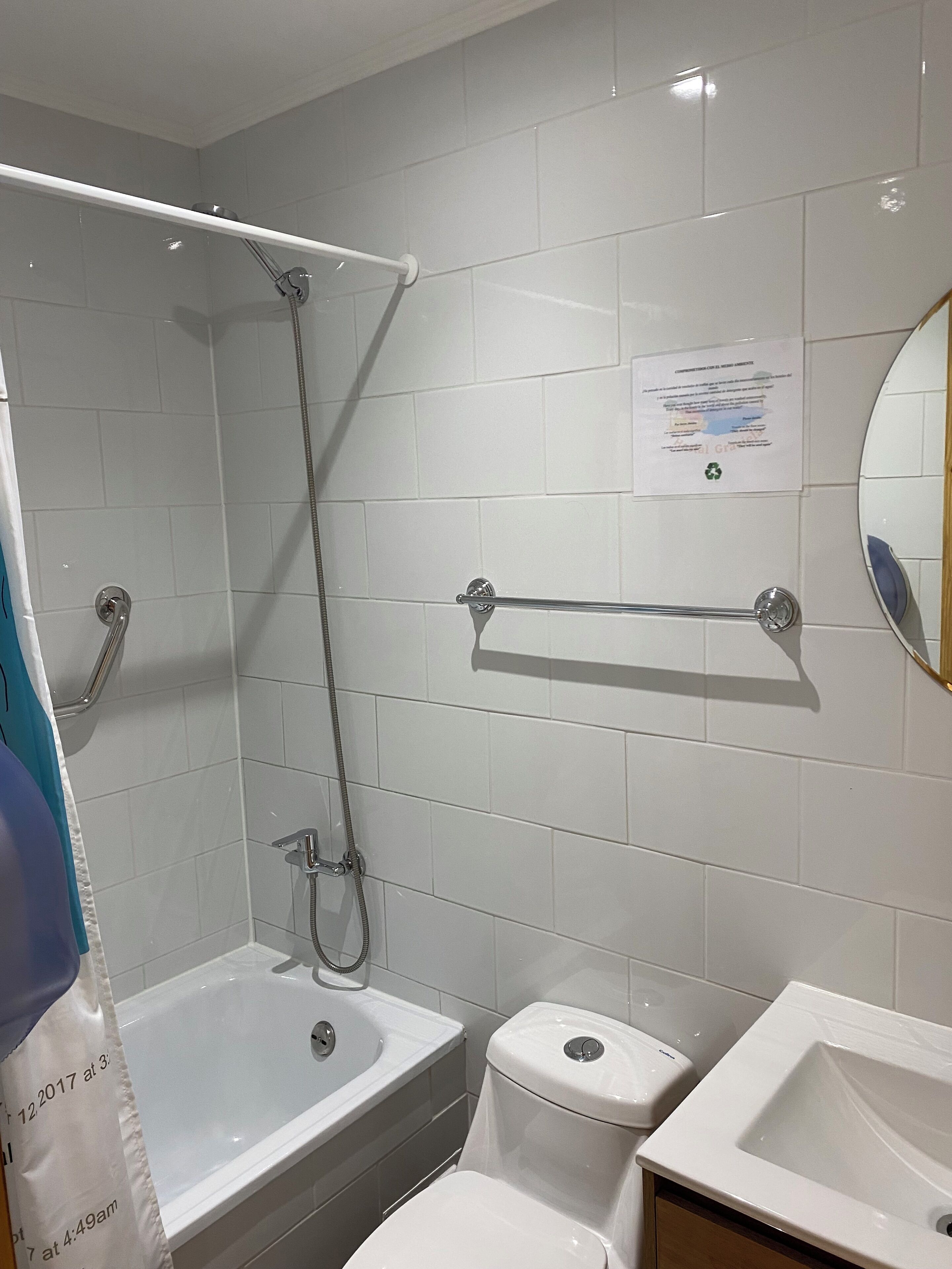A bathroom with a shower, toilet, and sink.