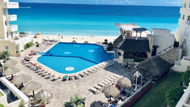 A resort with a large swimming pool, beach access, and a view of the ocean. - Ocean View Apartments – Delicia (Cancun)