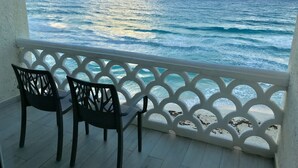 A balcony with two chairs overlooking the ocean. - Ocean View Apartments – Delicia (Cancun)