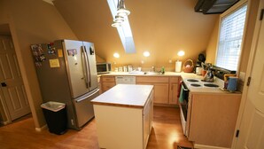 A compact kitchen with a refrigerator, microwave, stove, and sink. - Spacious Country Guest Apartment (Eugene)