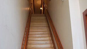 A wooden staircase with a handrail, leading to an upper floor. - Historic Downtown Condo-1 Bedroom (New Bern)