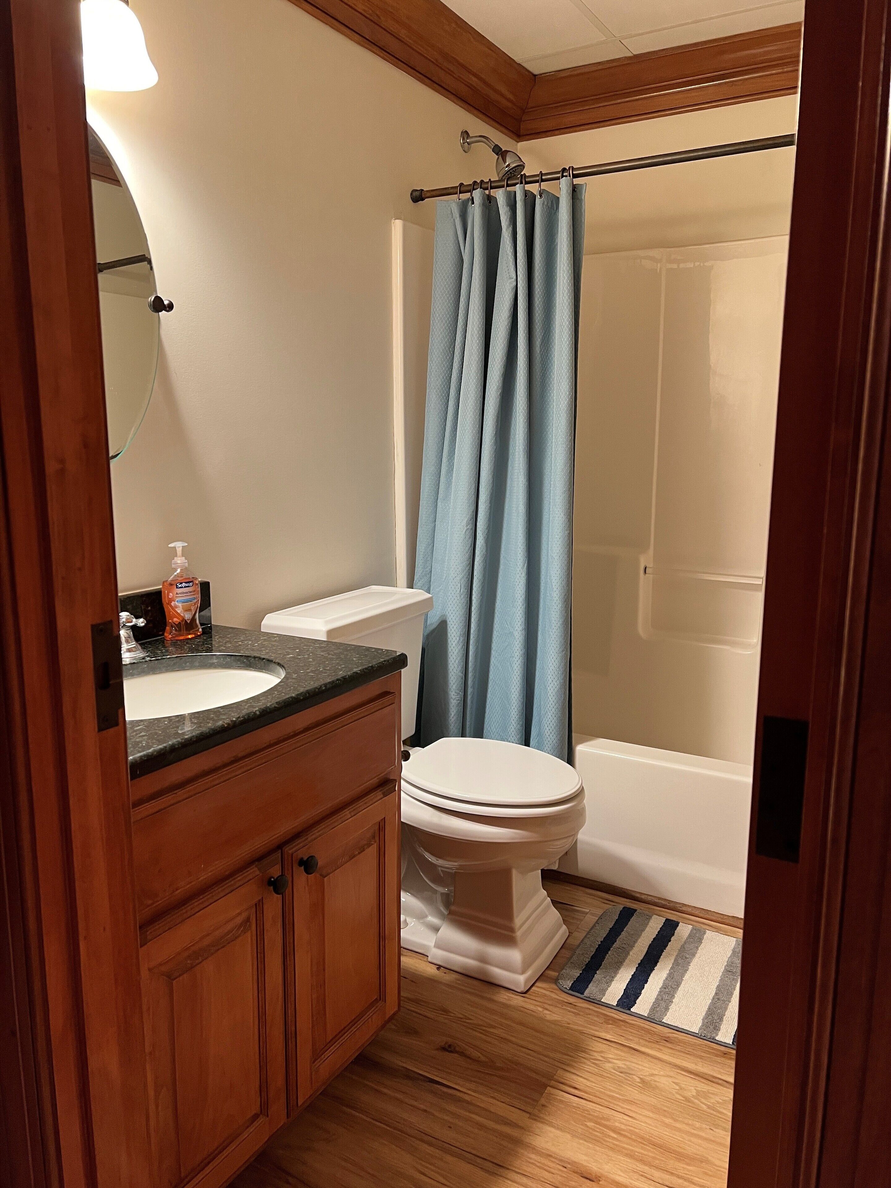 Een bad/douchecombinatie, een haardroger, handdoeken, zeep