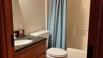 Een bad/douchecombinatie, een haardroger, handdoeken, zeep