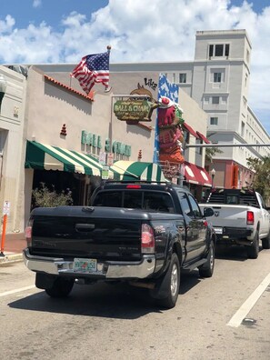 Una camioneta pickup negra estacionada frente a un edificio con un letrero que dice "Ball & Chain Bar and Lounge".