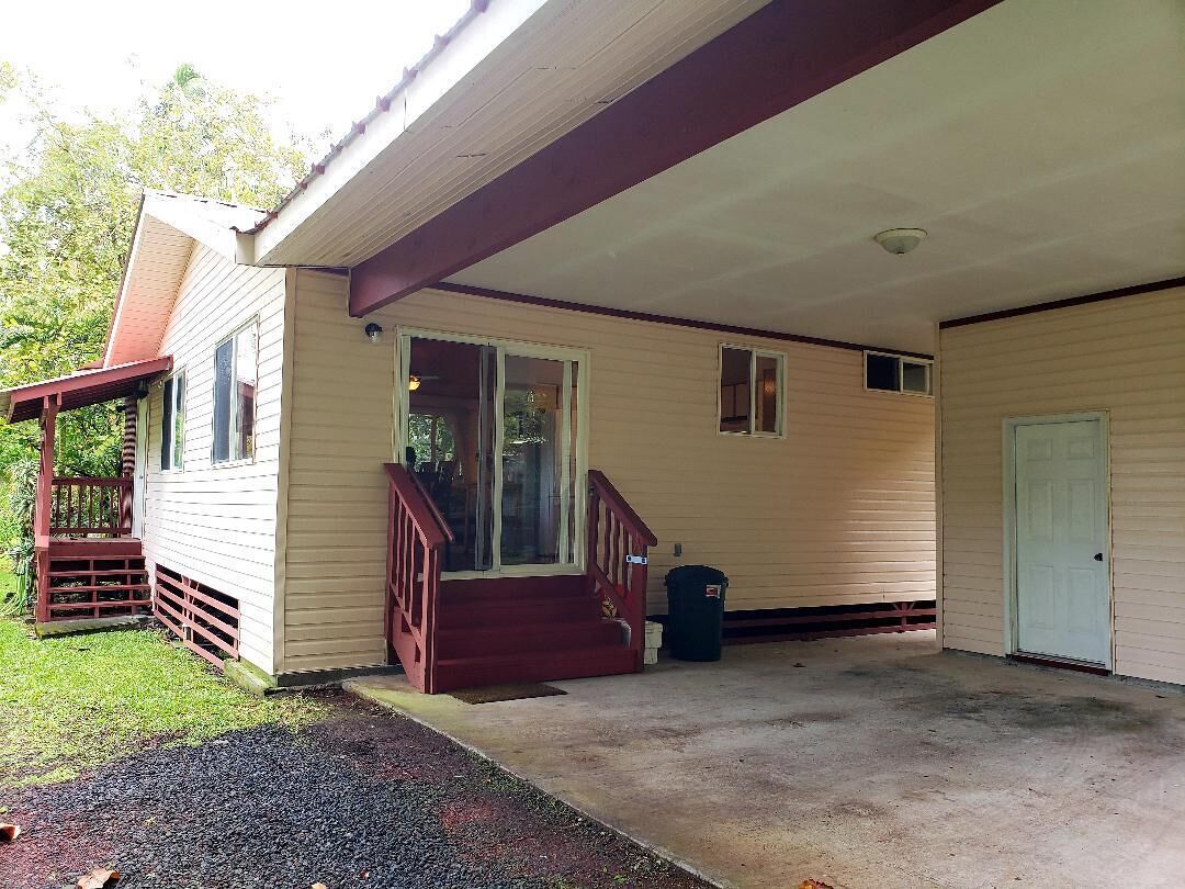 A single-story house with a covered porch, a front door, and a small front yard.