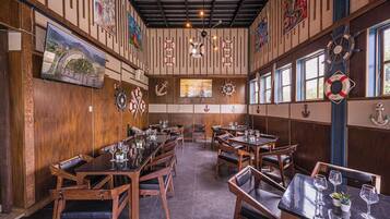 A restaurant with wooden walls, nautical decor, and multiple dining tables.