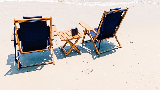 Two wooden beach chairs and a small table on a sandy beach with the ocean in the background. - 4X4 beach. Private Pool opens in May (Corolla)