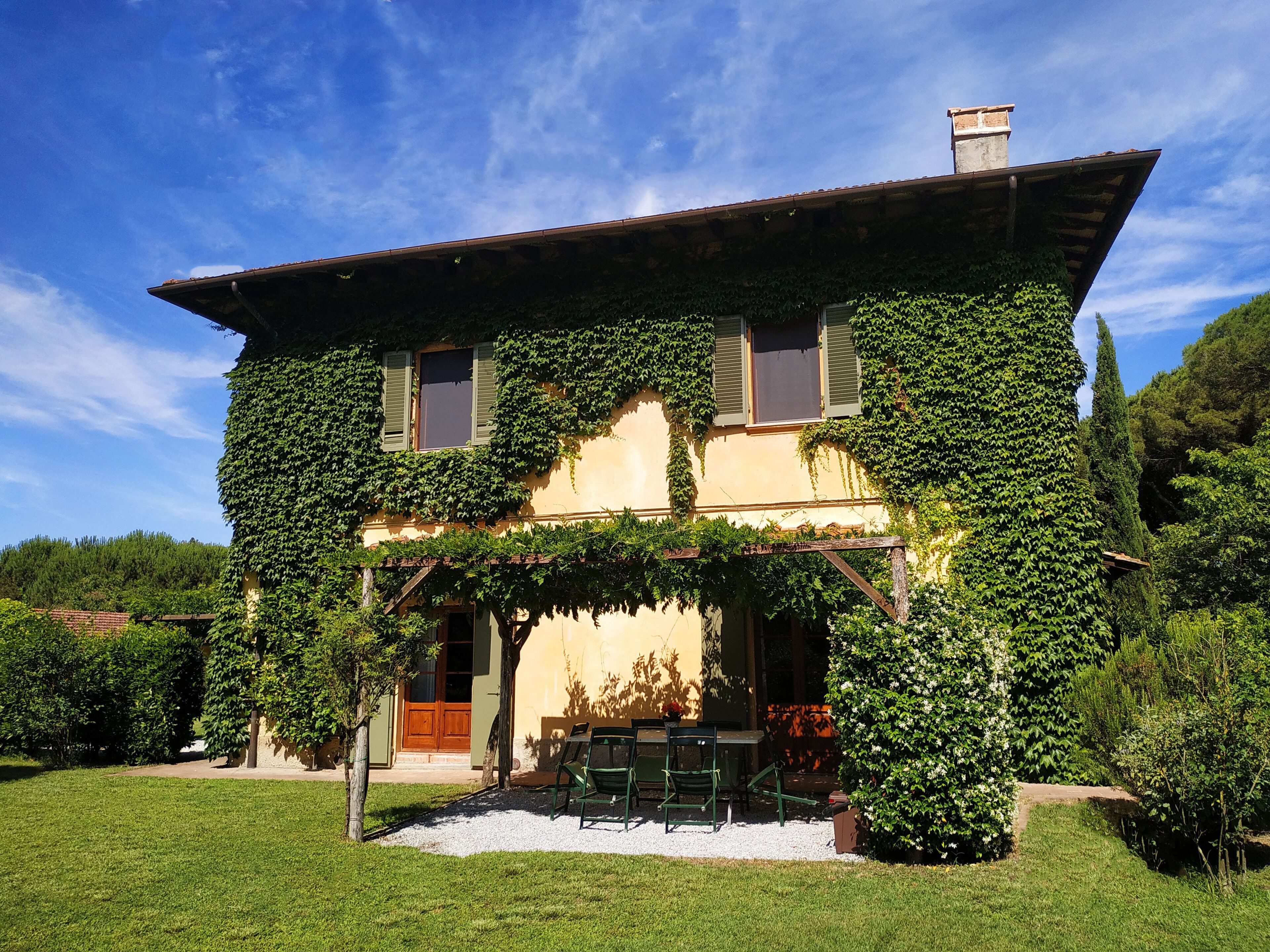 A two-story house with ivy-covered walls and a wooden porch.
