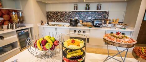 A buffet table with various fruits and snacks.