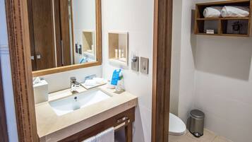 Une salle de bain équipée d’un lavabo, d’un miroir, d’un porte-serviettes et d’une étagère avec des serviettes.