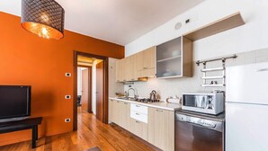 A modern kitchen with wooden cabinets, a built-in microwave, and a dishwasher. - Novalesi Apartment (20 minutes from Venice) (Noale)