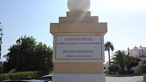 A sign for a private condominium with a spherical top, located in a sunny outdoor area with palm trees and a clear sky. - Beautiful Residential Villa on An Exclusive Private Complex, pool, roof terrace (Carvoeiro)
