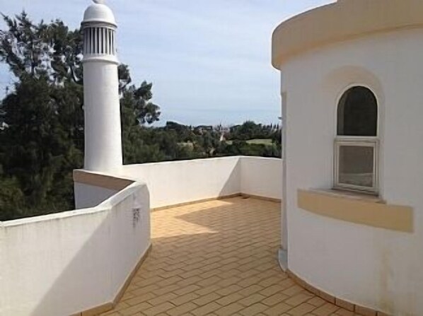 A rooftop terrace with a tiled floor, a white wall, and a small window. - Beautiful Residential Villa on An Exclusive Private Complex, pool, roof terrace (Carvoeiro)