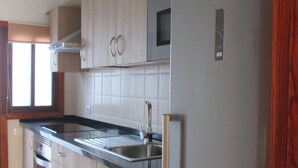 Una cocina moderna con armarios de madera, electrodomésticos de acero inoxidable y un microondas integrado.