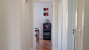 A hallway with wooden flooring, white walls, and a door on the right. - Lisbon Beach Apartments 3. Beach 5 minutes, terrace, barbecue, pets welcome (Costa da Caparica)