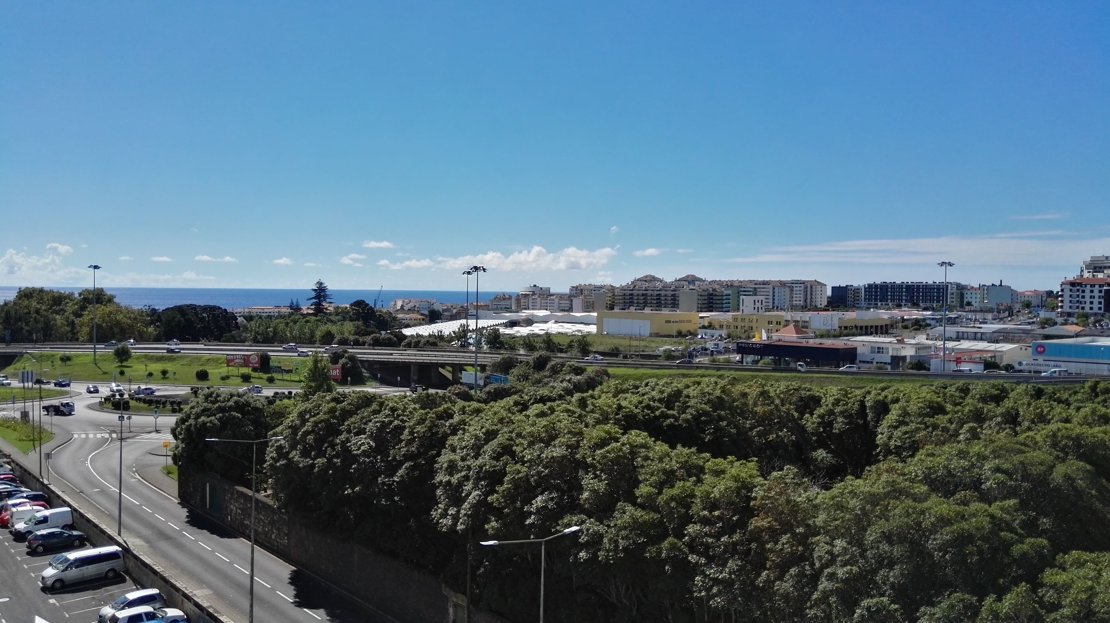 Eine Stadtansicht mit Autobahn, Gebäuden und blauem Himmel.