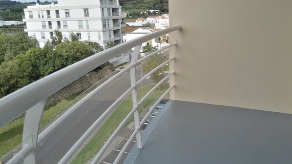 A balcony with a metal railing overlooking a road and buildings. - ★ Green & Blue ★ 3Br, in Ponta Delgada ❤ view over city + sea (Fajã de Baixo)