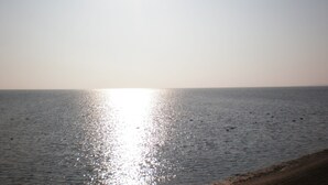 Une plage où le soleil se reflète sur l’eau.