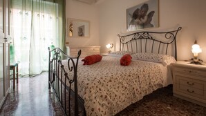 A bedroom with a bed, bedside tables, a mirror, and a window with curtains. - Wonderful apartment in the center of Rome 100 meters from Vatican  (Roma)