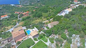 Un pueblo costero con casas escalonadas, una piscina y vistas al mar.