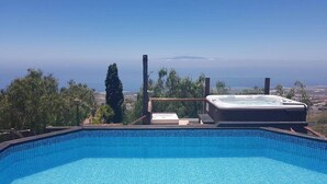 Ein klares, blaues Schwimmbecken mit Whirlpool und Blick auf die Landschaft.