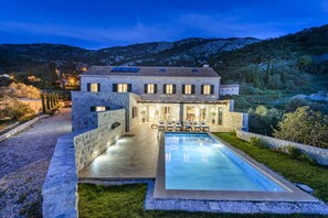 A stone villa with a swimming pool, outdoor seating, and a mountain backdrop. - Villa Panoramic View by MyWaycation (Dubravka)