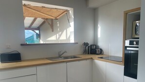 A compact kitchen with a wooden countertop, a built-in sink, and a coffee maker.