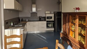 Una cocina moderna con armarios blancos, un refrigerador de acero inoxidable y un microondas.