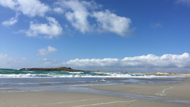 A beach with waves, a clear sky, and a distant rocky outcrop. - Fisherman's cottage in St Guénolé, near Pors Carn, La Torche (Penmarch)