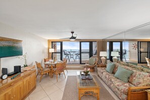 Un vaste espace de vie comprenant une table à manger, des chaises, un canapé et un balcon avec vue.