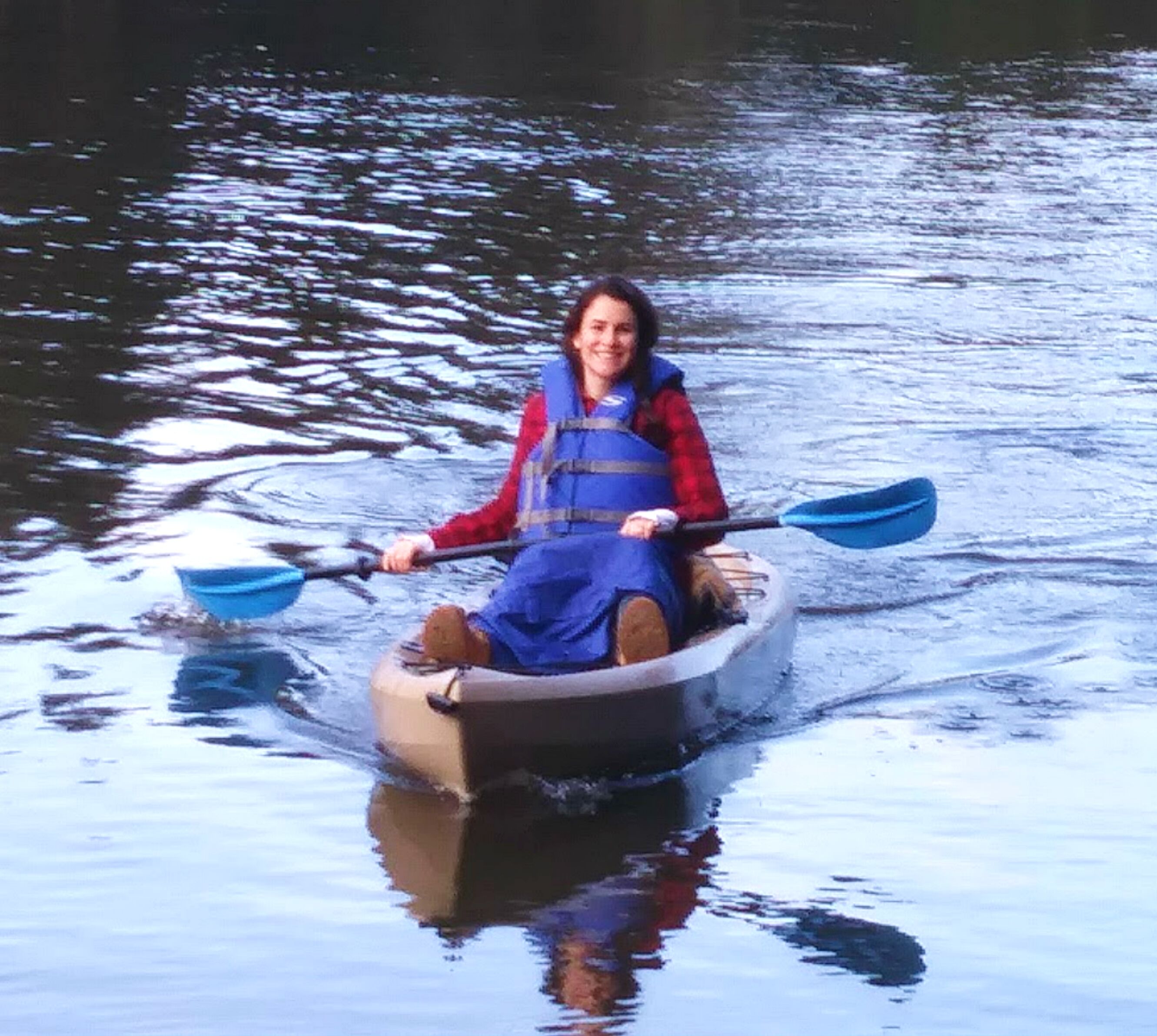 A person in a small inflatable boat on a body of water.
