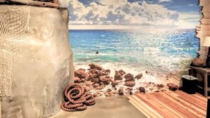 A room with a beach mural, a rope, and a wooden bench.