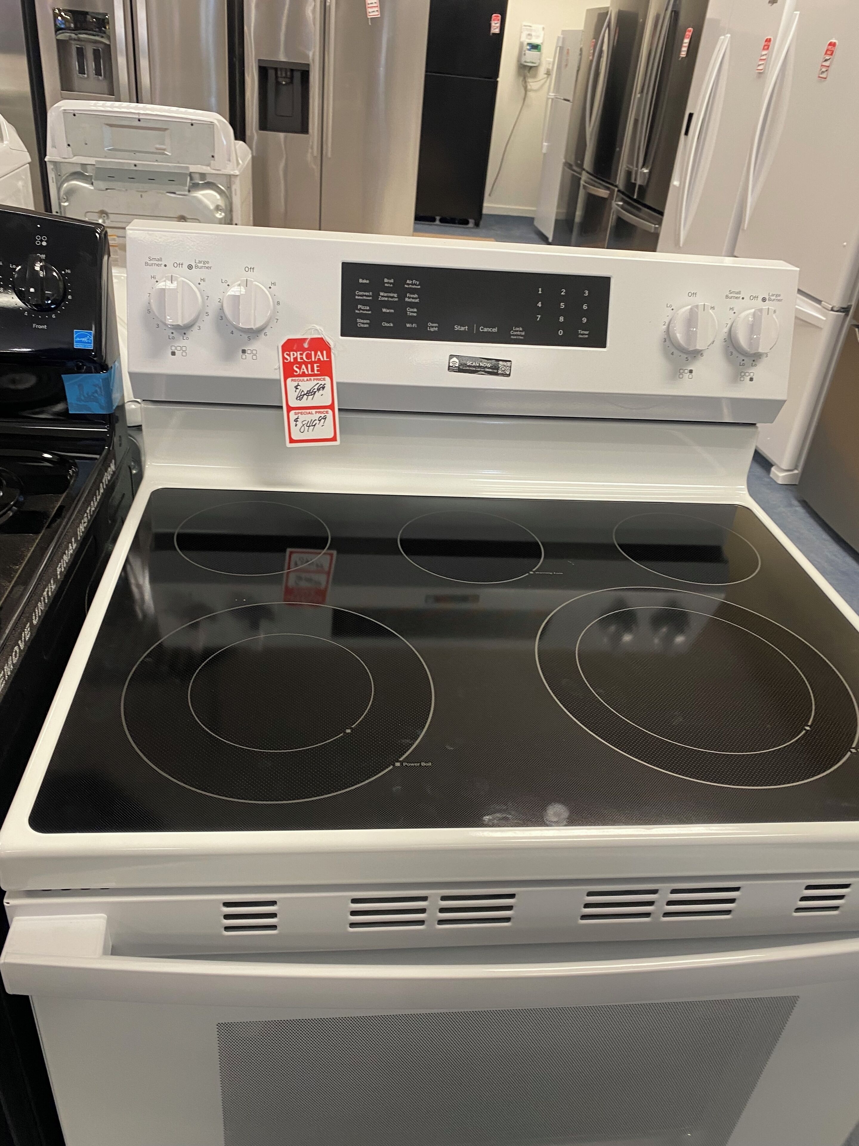 A kitchen with a white stove, two burners, and a digital control panel.