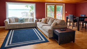 A living room with two sofas, a coffee table, and a dining table with chairs. - Prime location - Ranch House on Seneca Lake (Romulus)